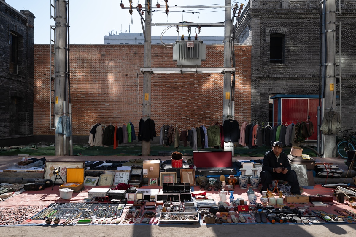 Marché de rue avec vêtements et objets divers en vente.