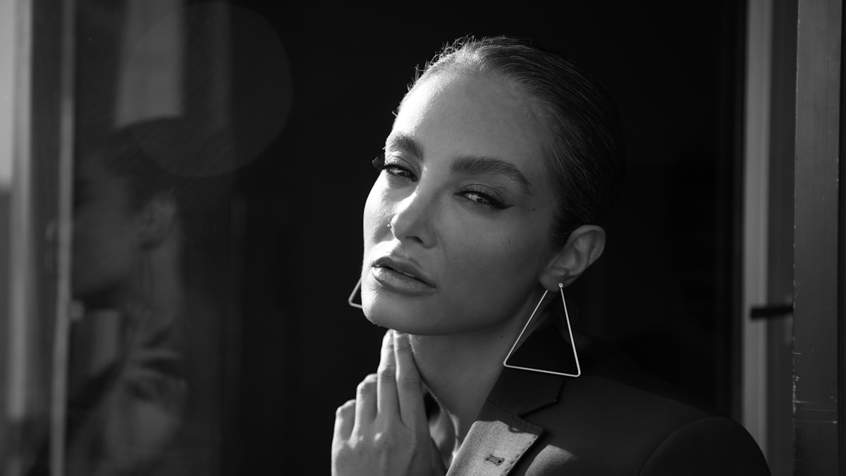 Une photo en noir et blanc d'une femme portant des boucles d'oreilles.