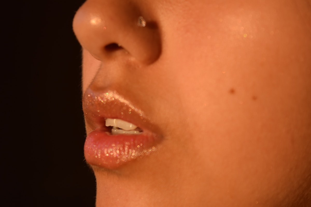 Une bouche de femme en gros plan sur fond noir.