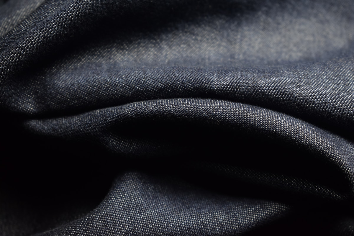 Texture de tissu bleu foncé avec des plis et des ombres.