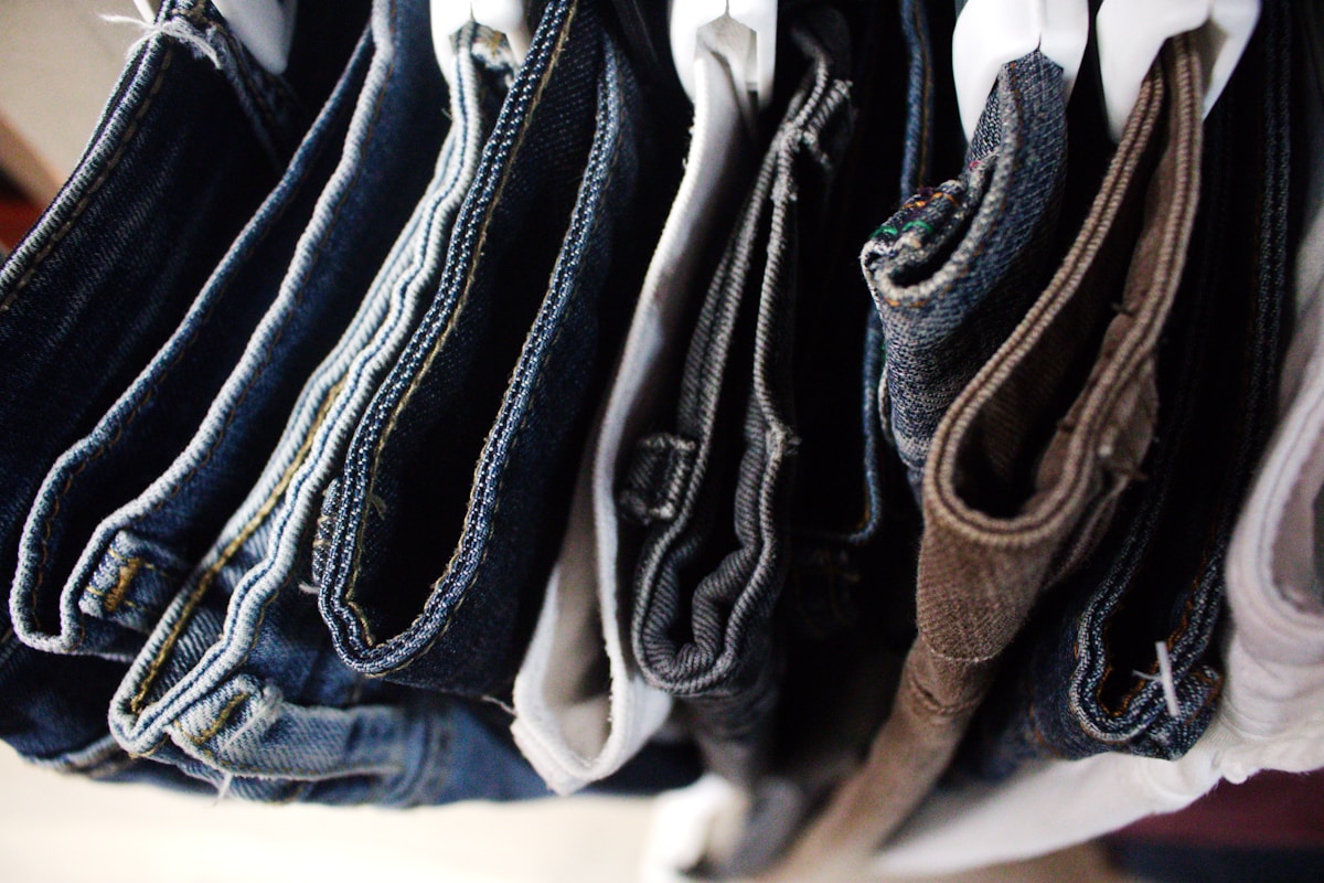 Vêtements en jean suspendus, variété de couleurs et de textures.