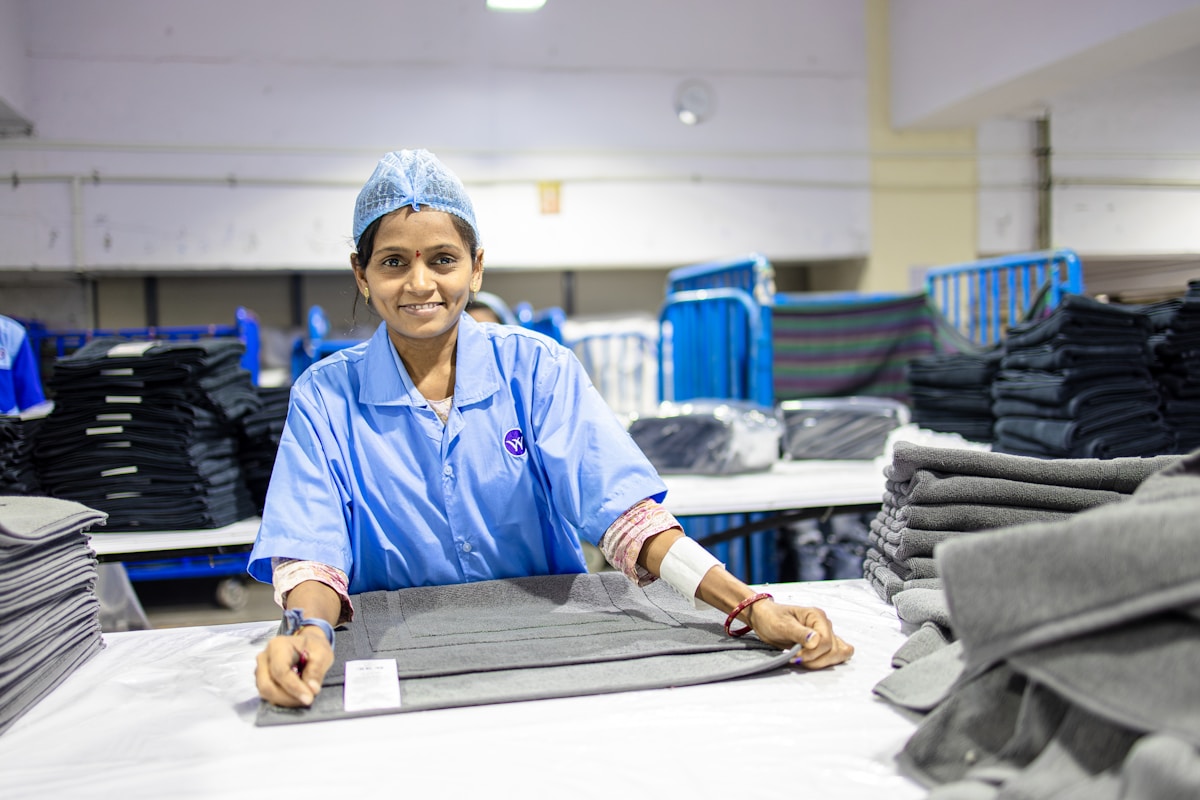 Travailleuse souriante dans une usine de vêtements.