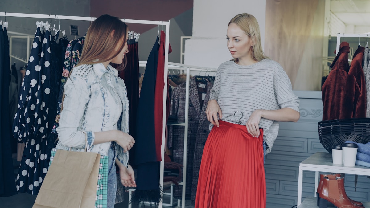 Deux femmes discutant dans un magasin de vêtements.