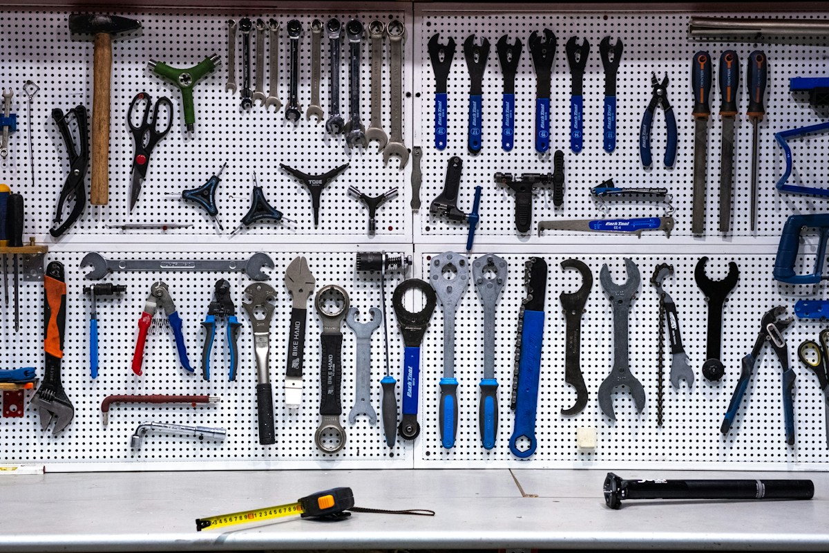 Mur perforé couvert d’outils de mécanique et mesure.