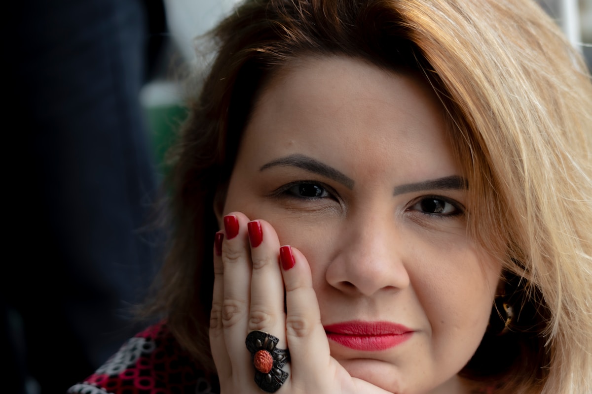 Femme aux lèvres rouges et manucure rouge.