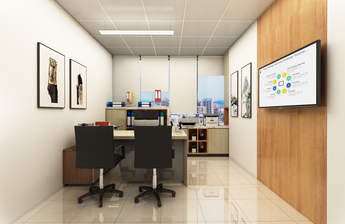 Bureau moderne avec des bureaux, des chaises et un écran de présentation.