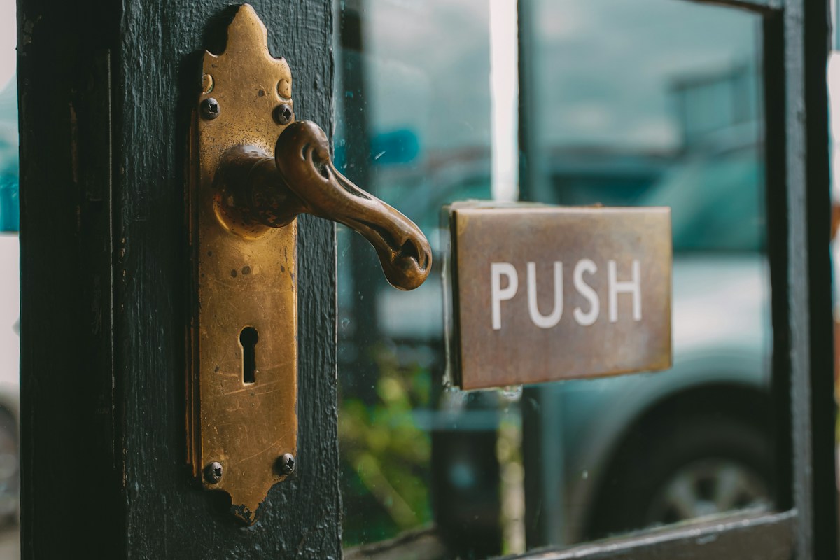 Poignée en laiton et panneau « PUSH » sur porte vitrée
