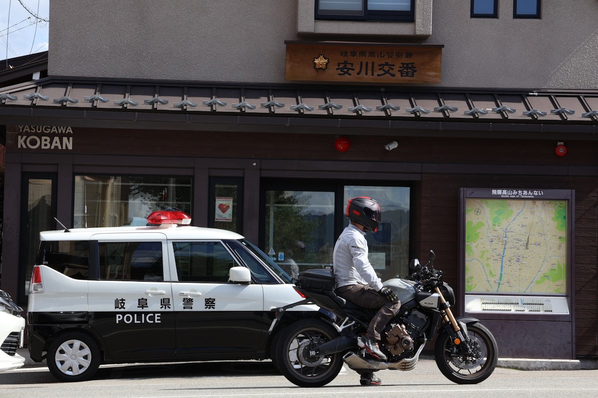 Voiture de police et motard devant un commerce japonais.
