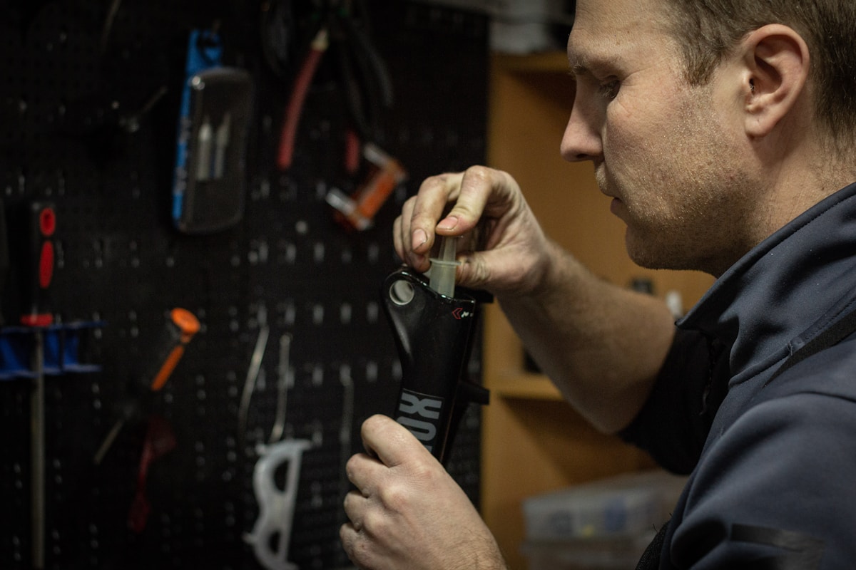 Homme réparant un équipement électronique dans un atelier.
