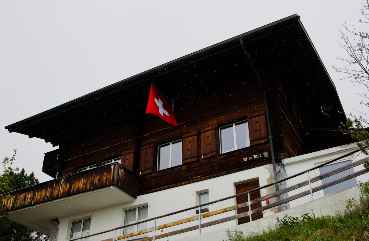 Chalet suisse avec drapeau national sur le toit.
