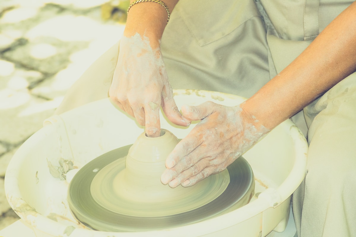 Mains d'un artisan façonnant de la poterie sur un tour de potier.
