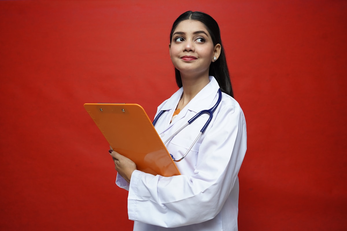 Jeune femme médecin souriante tenant un dossier médical.