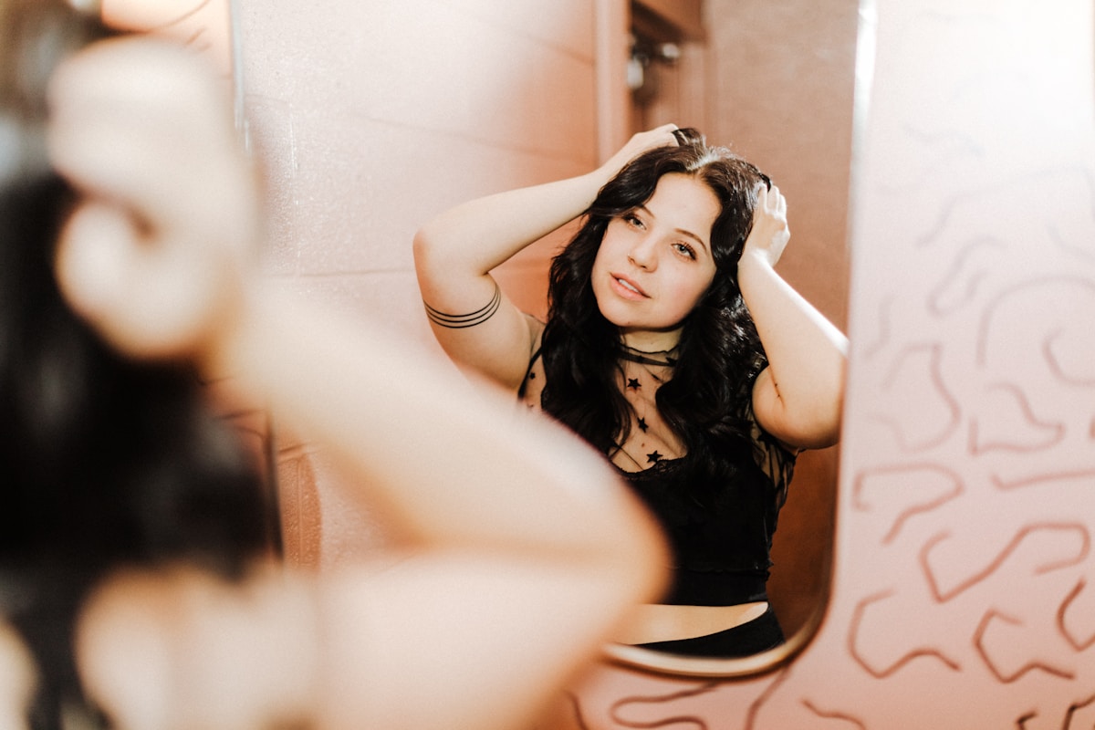 Jeune femme brune posant de manière sensuelle dans un décor abstrait.