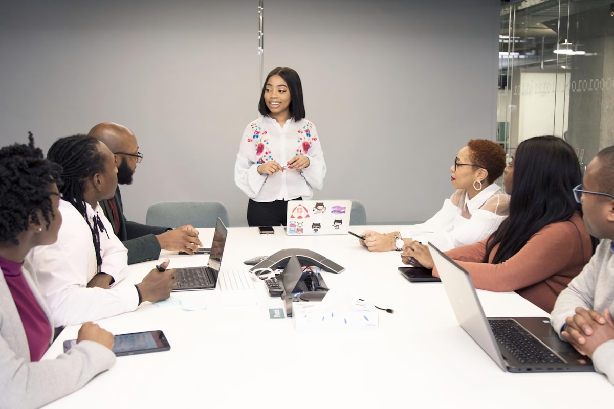 Groupe diversifié de personnes en réunion de travail dans un bureau moderne.