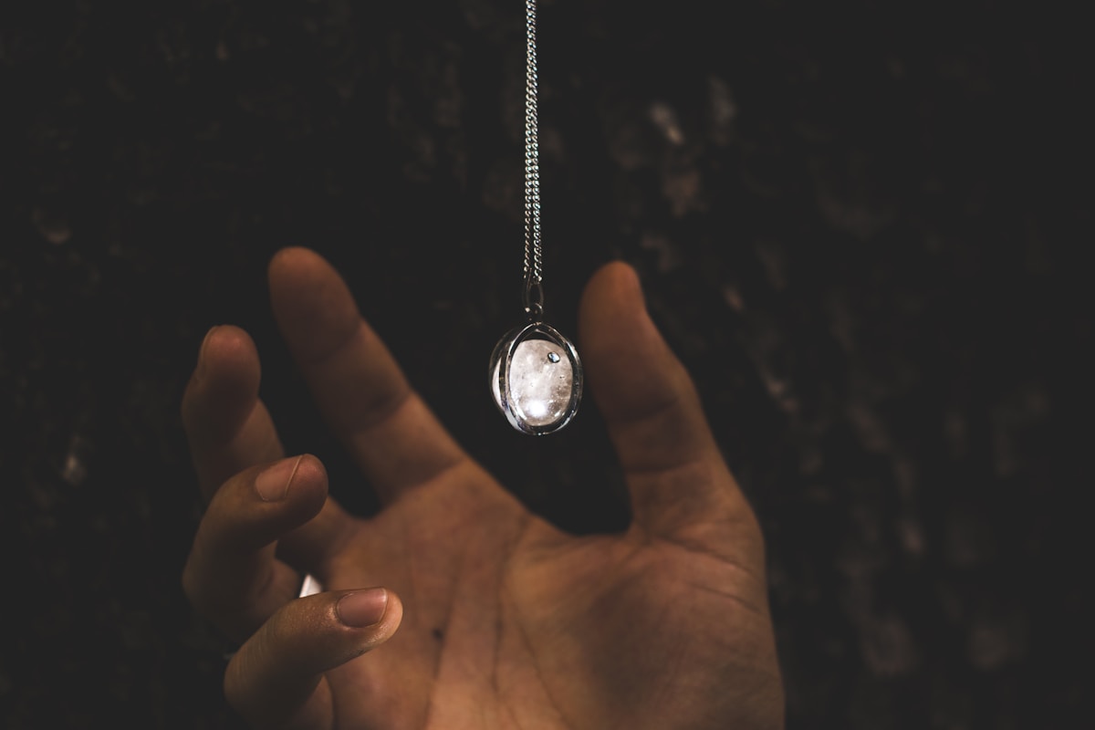 Pendentif en forme de lune suspendu dans l'obscurité.