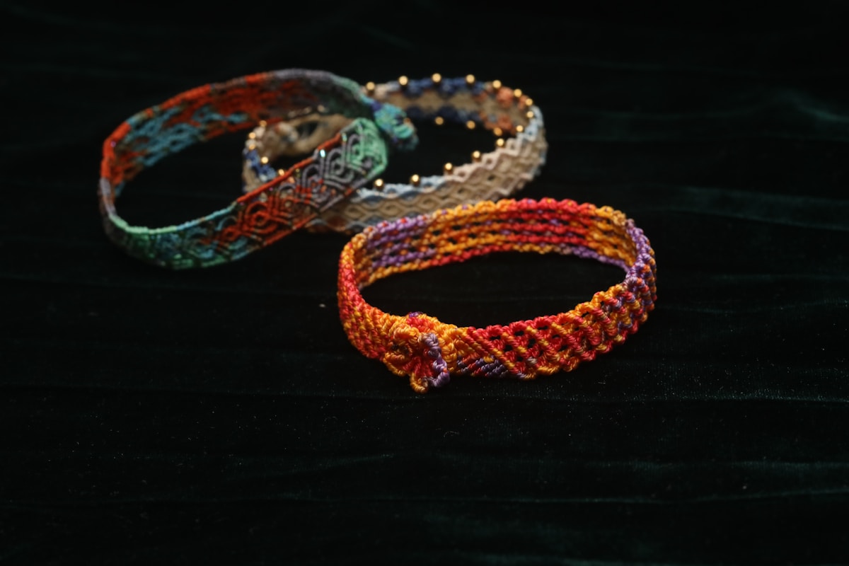 Bracelets colorés et ornementés sur fond noir.