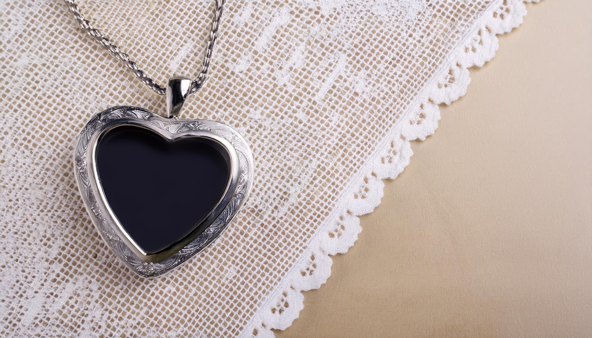 Pendentif en forme de cœur noir sur dentelle blanche.