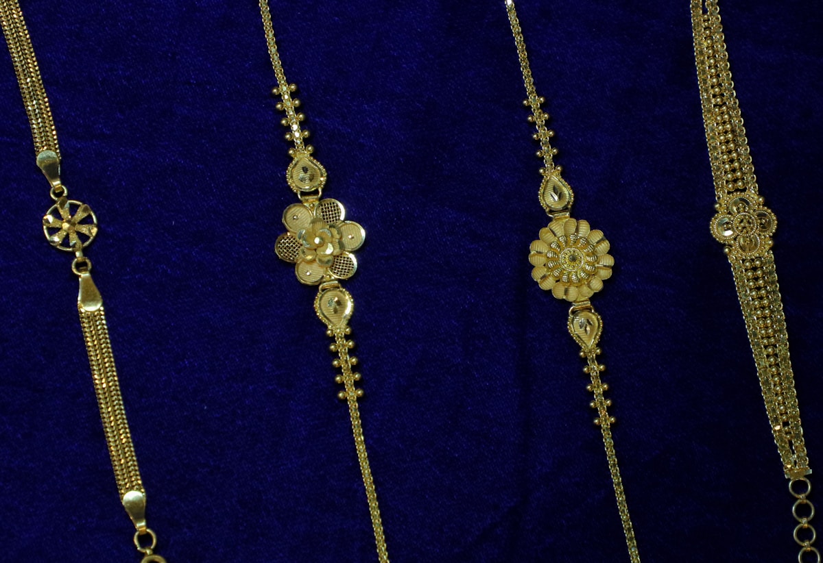 Colliers de bijoux dorés avec motifs floraux et pierres précieuses.