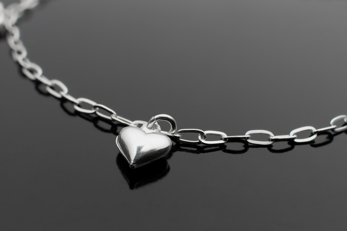 Collier en métal argenté avec pendentif en forme de cœur.
