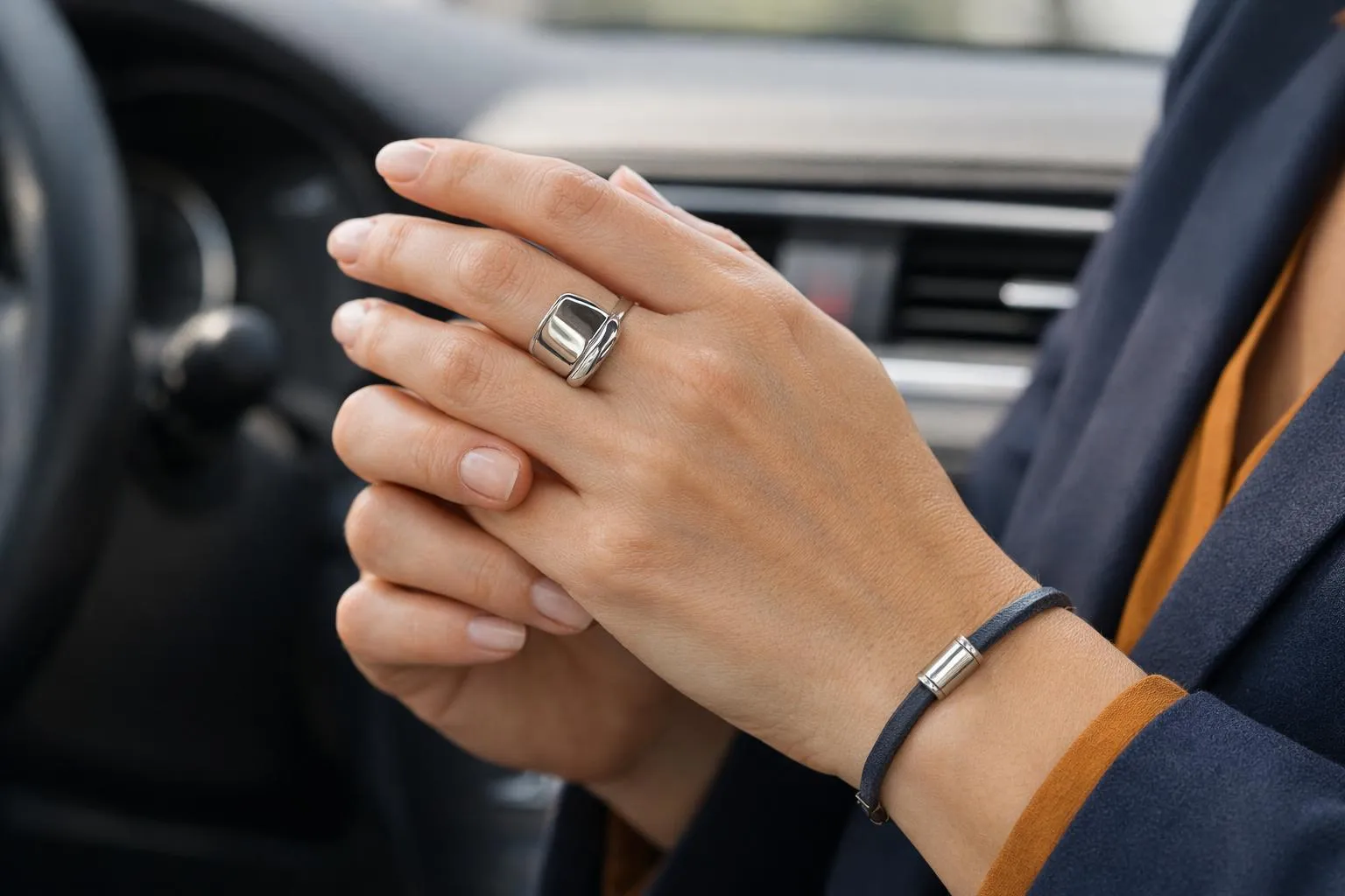 Mains gantées d'un conducteur portant une bague et un bracelet.