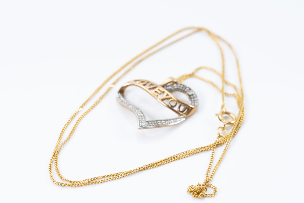 Collier en or avec pendentif en forme de cœur orné de diamants.