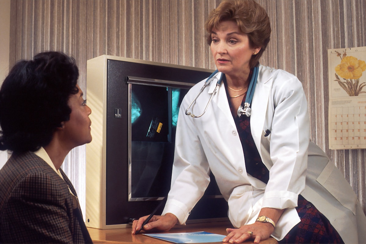 Médecin féminin examinant une radiographie avec une patiente.