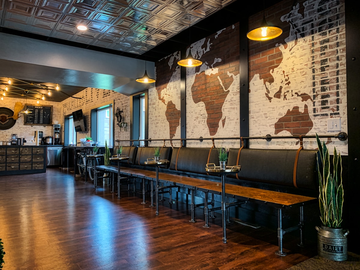 Intérieur d'un café avec un mur décoré d'une carte du monde en briques.