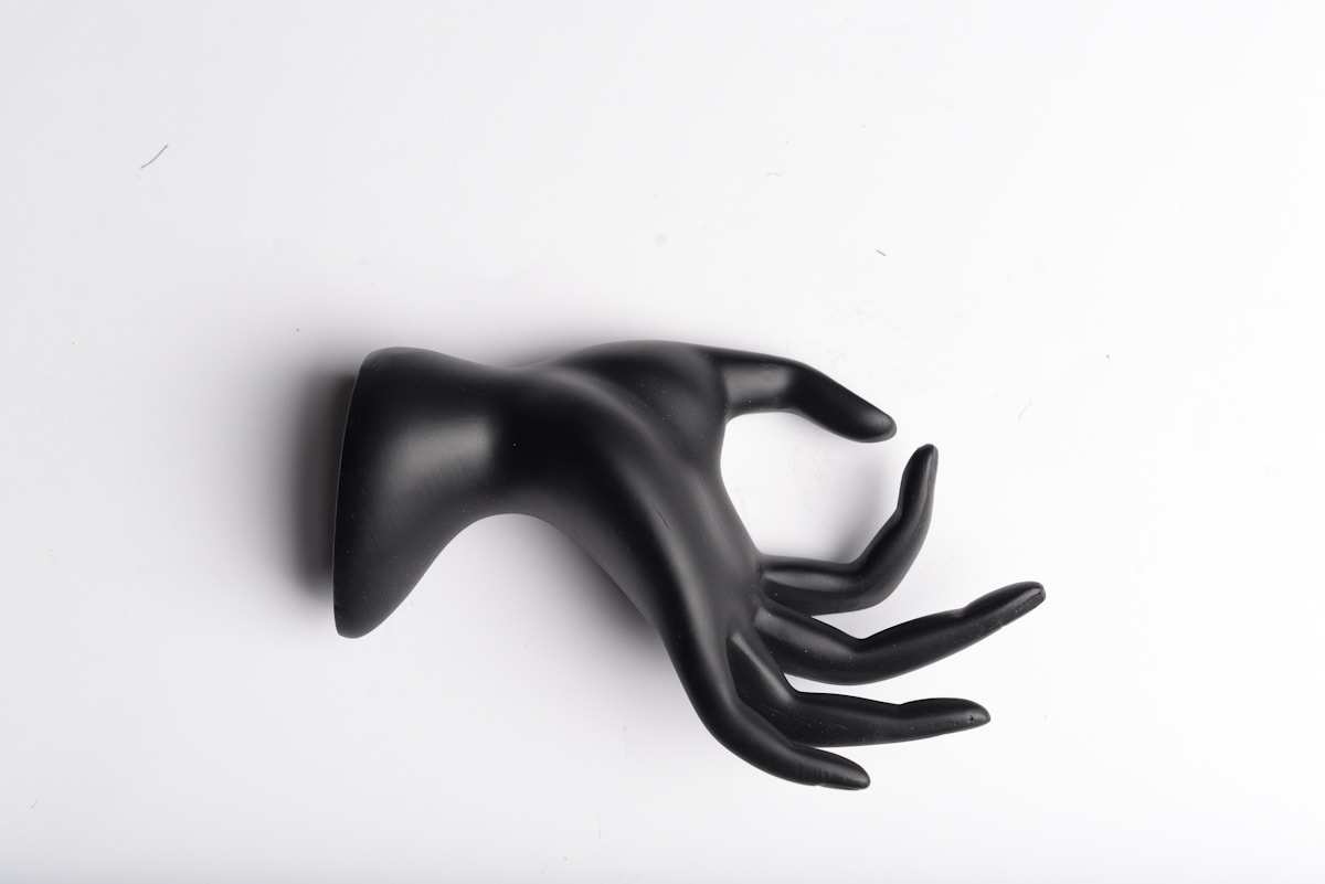 Sculpture abstraite noire en forme de main.