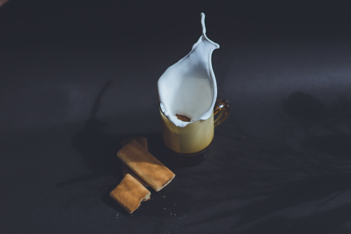 Verre de cocktail avec mousse blanche et biscuits dorés.