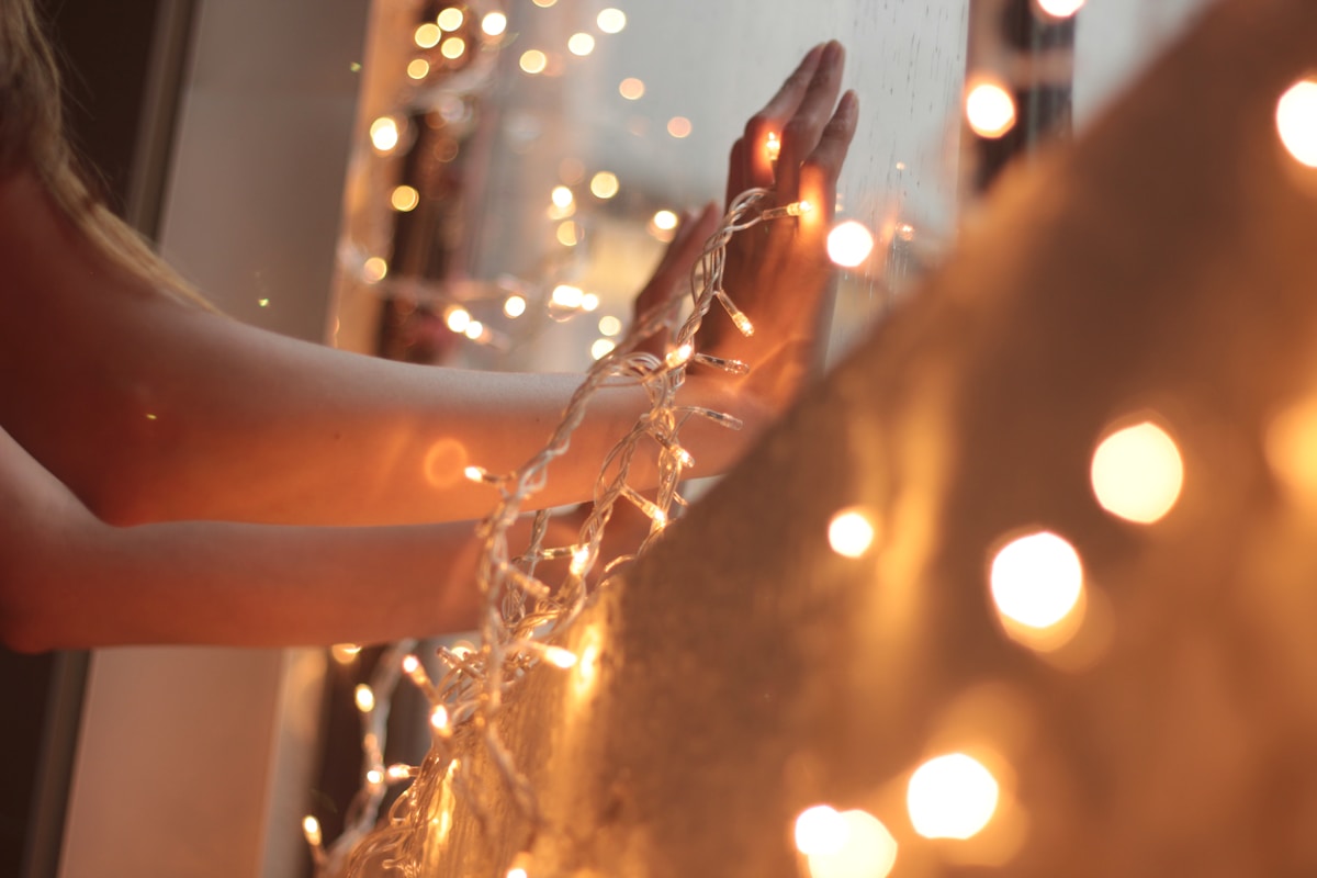 Guirlande lumineuse accrochée sur un mur en bois avec des lumières scintillantes.