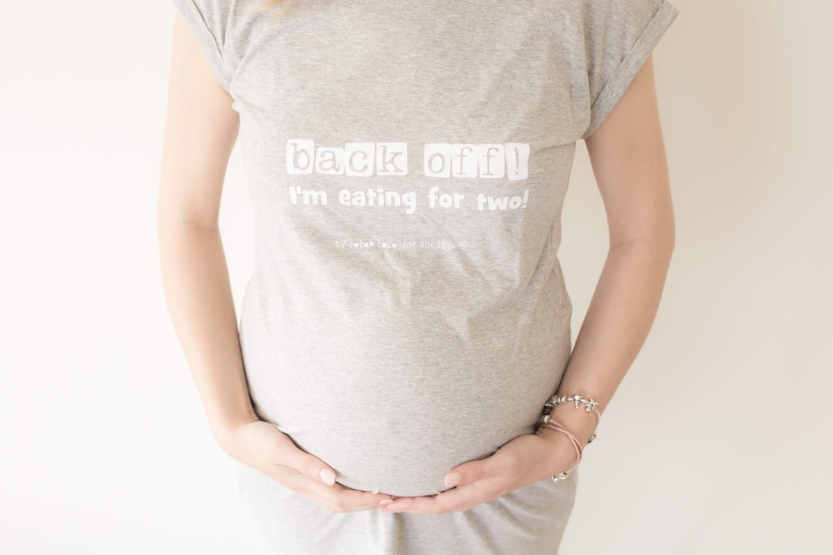 T-shirt gris avec texte humoristique sur la grossesse.