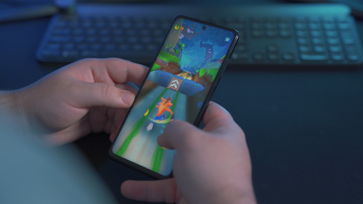 Personne jouant à un jeu mobile sur un smartphone.