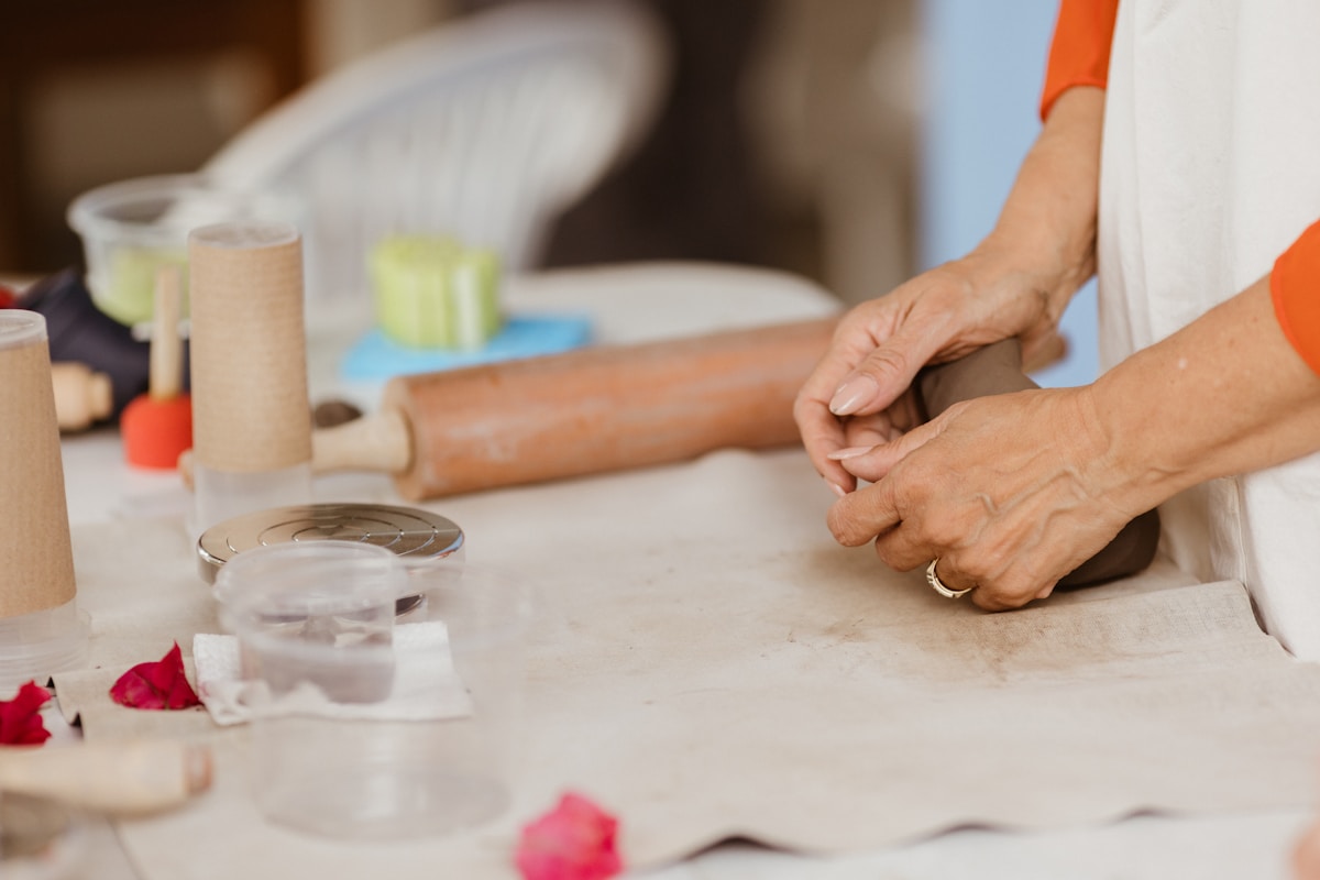 Mains pétrisseuses de pâte sur une surface de travail.