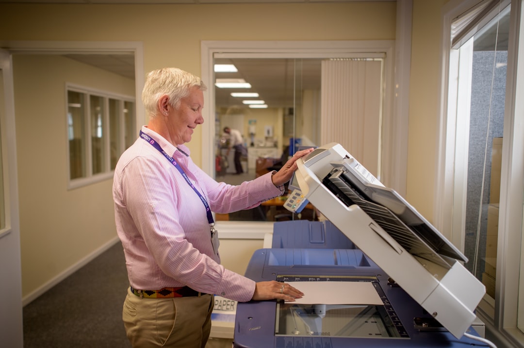 impression grand format bâches prix m2 - A professional printing technician inspecting a large-format banner being printed on