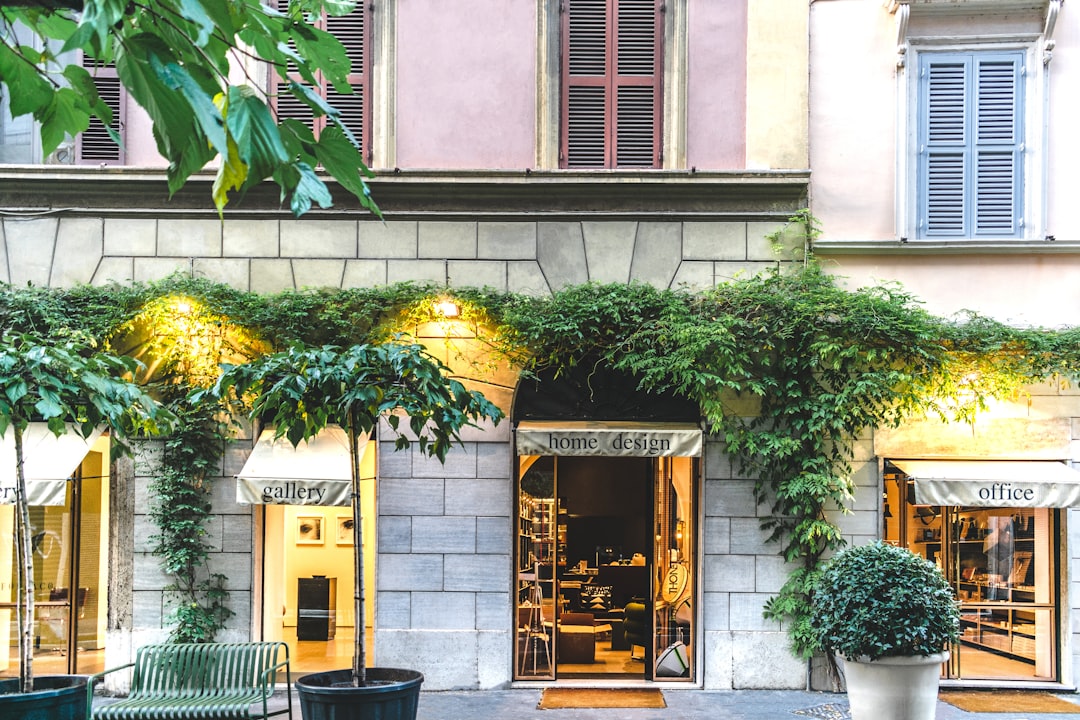 impression grand format bâches prix m2 - A storefront in a European city with a large professionally printed vinyl banner cov