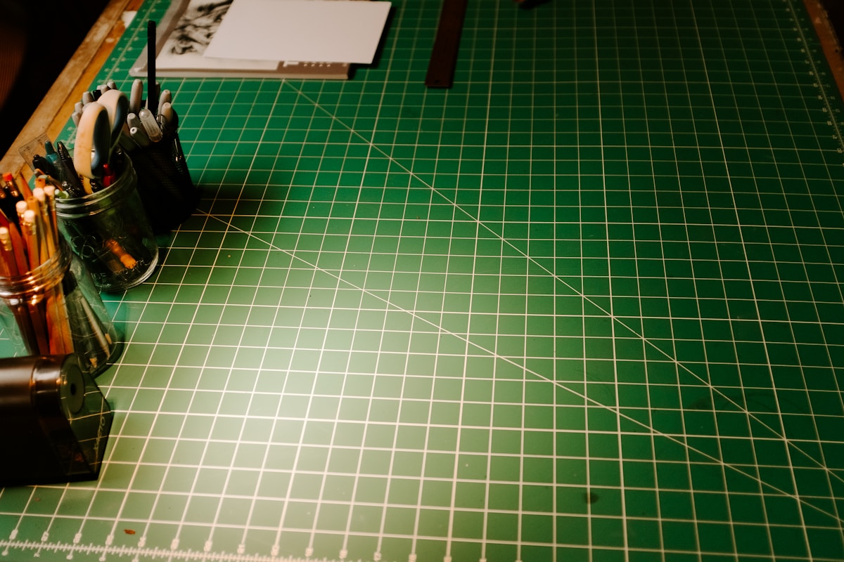 Plateau de coupe vert quadrillé avec outils de bricolage.