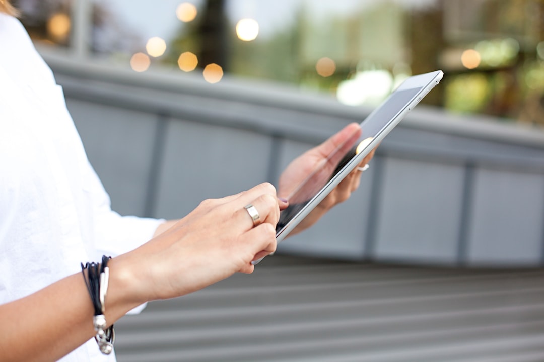 Maines manipulant une tablette montrant un tableau de bord KPIs, illustrant un logiciel gestion pme professionnel.