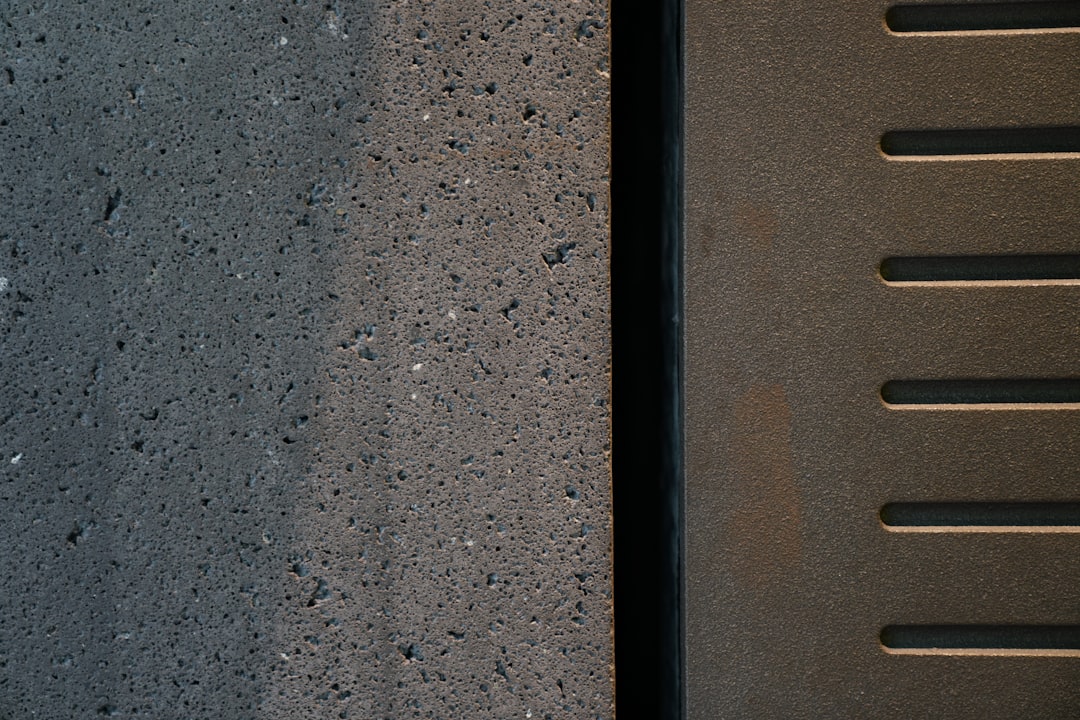 "Panneau de rue en acier brut vs thermolaqué, comparaison de finition sur un bâtiment urbain"