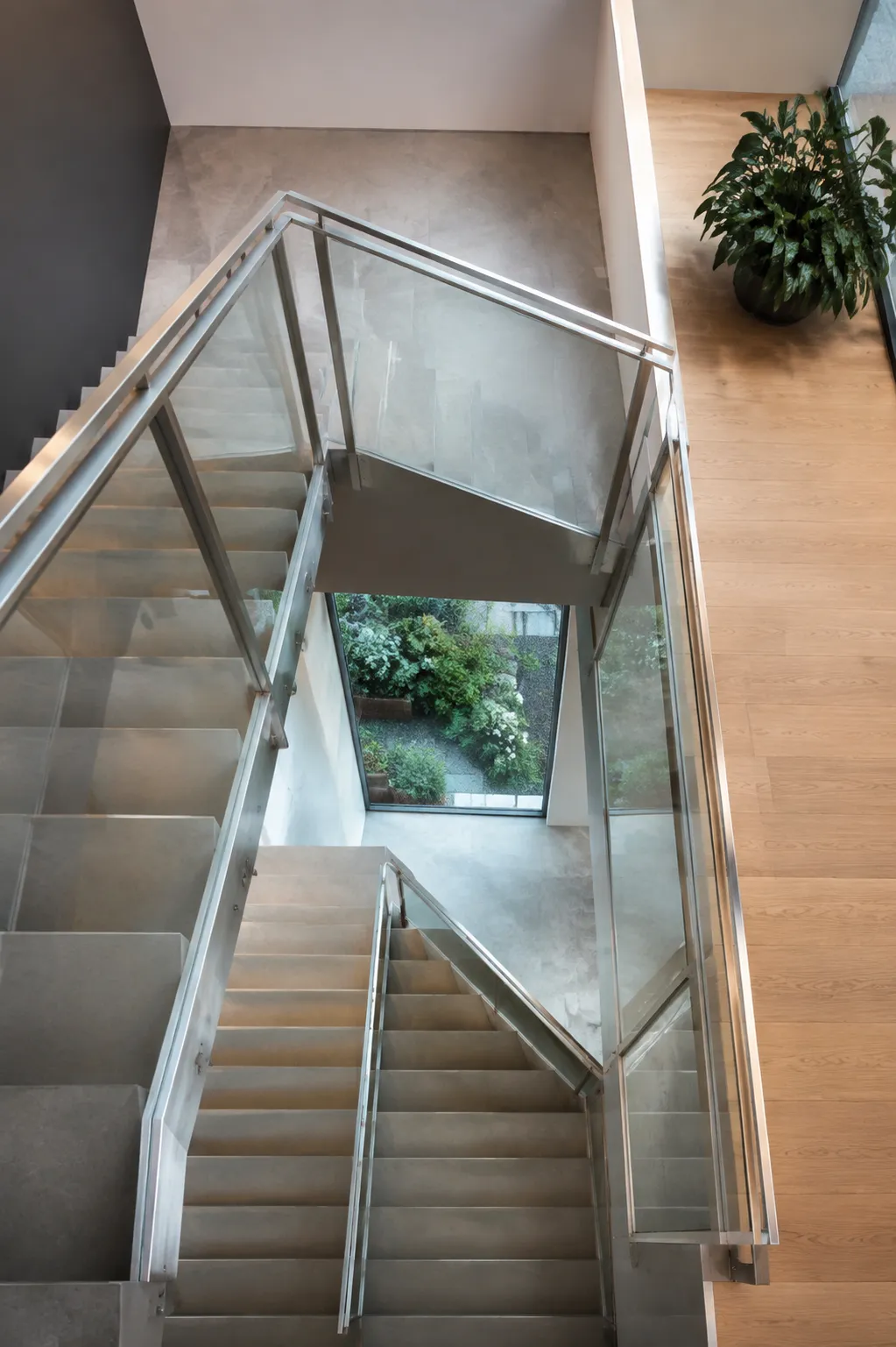 Escalier en verre et métal avec vue sur la nature.