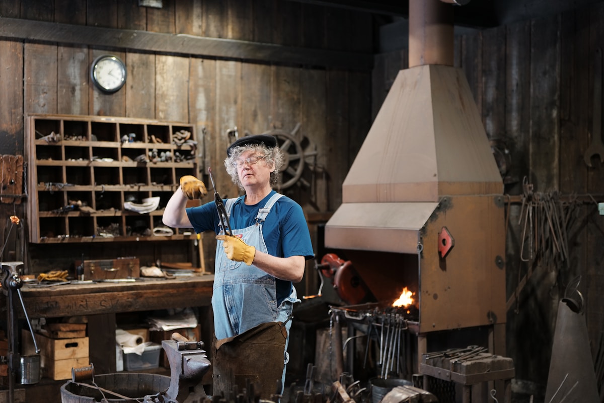 Artisan âgé travaillant dans un atelier rustique encombré.