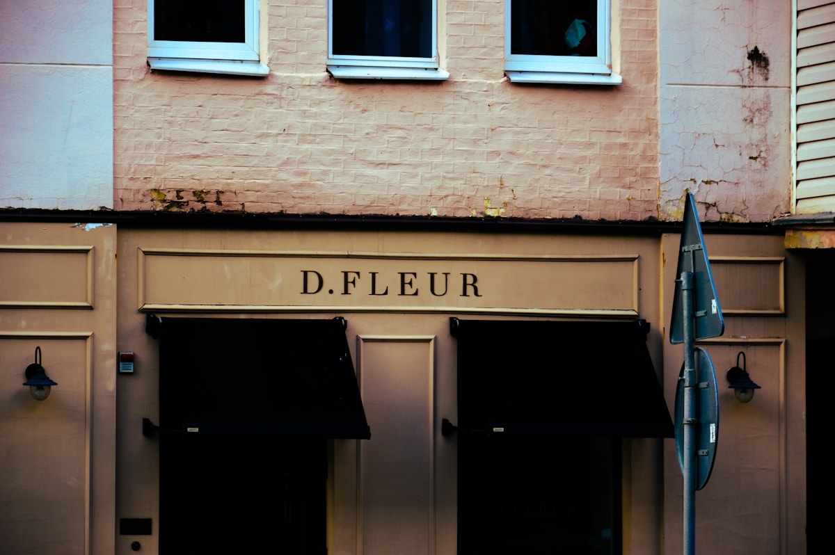 Façade de bâtiment avec enseigne "D.FLEUR", portes et fenêtres.