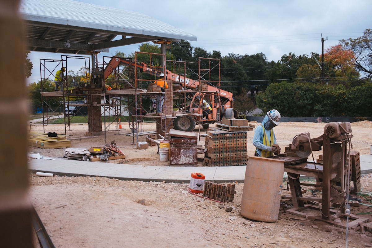 Chantier de construction avec équipements, matériaux et ouvriers.