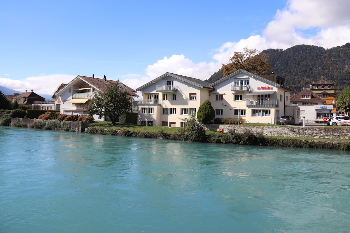 Paysage pittoresque de maisons au bord d'une rivière turquoise.