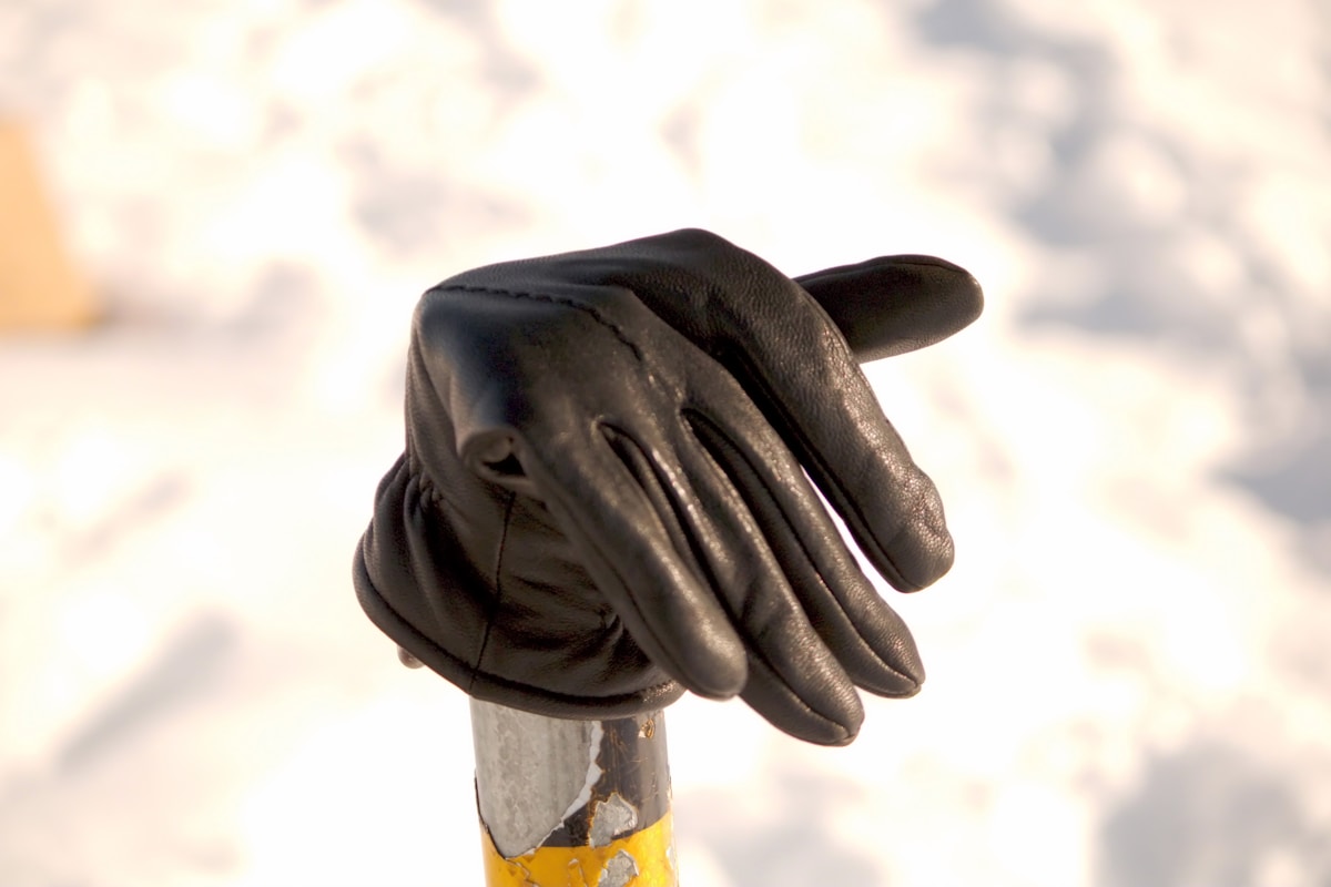 Gants de protection noirs sur un bâton en bois.