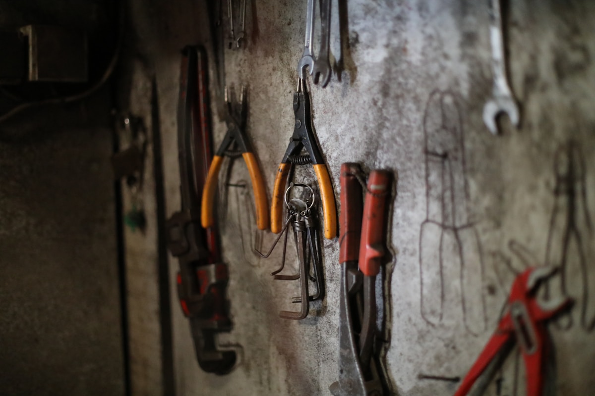 Outils de bricolage accrochés sur un mur rugueux.