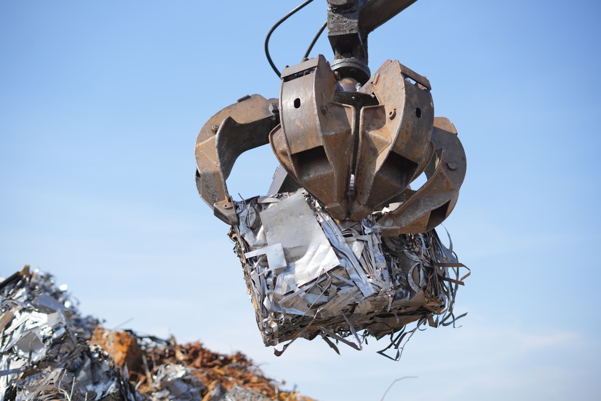 Grappin mécanique saisissant des déchets métalliques dans une décharge.