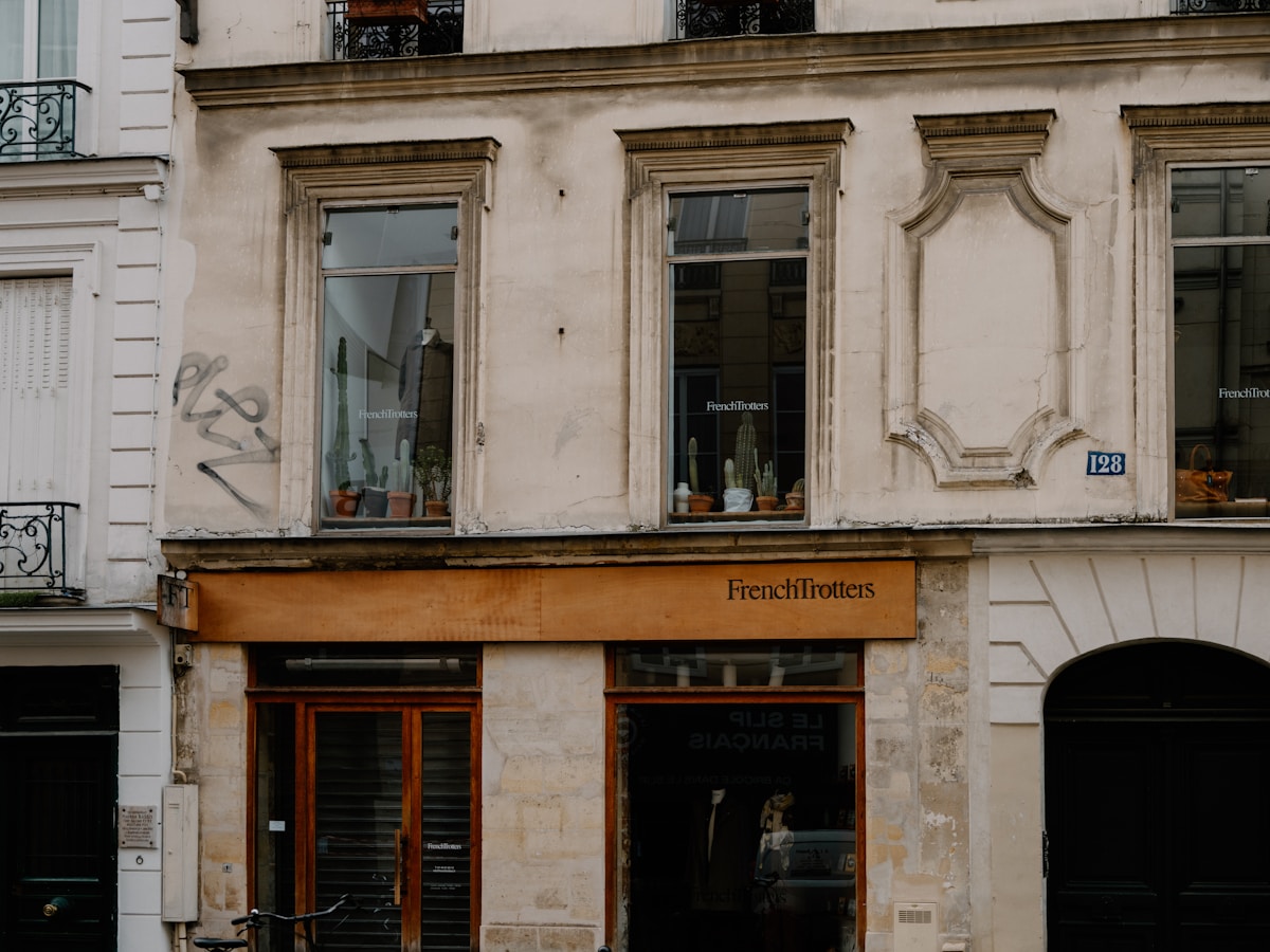Façade d'un magasin français avec des fenêtres ornées et une enseigne "FrenchTrotters".