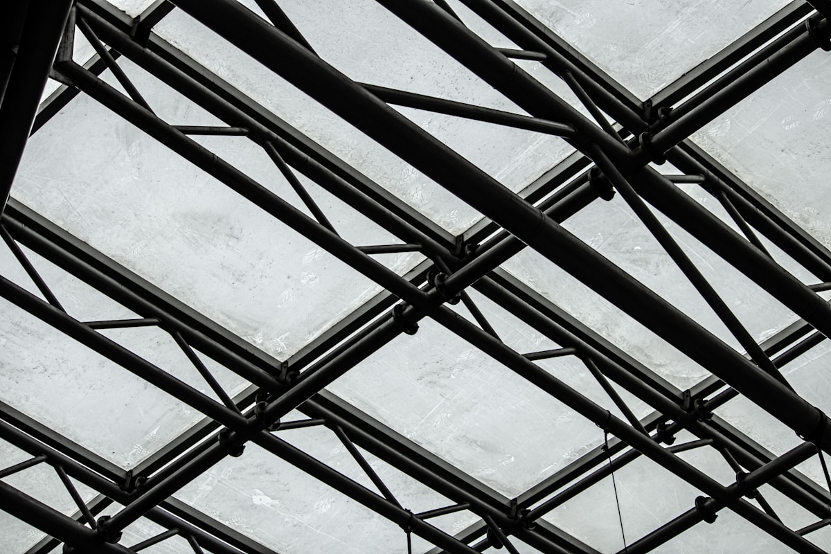 Structure métallique noire complexe sur fond gris.