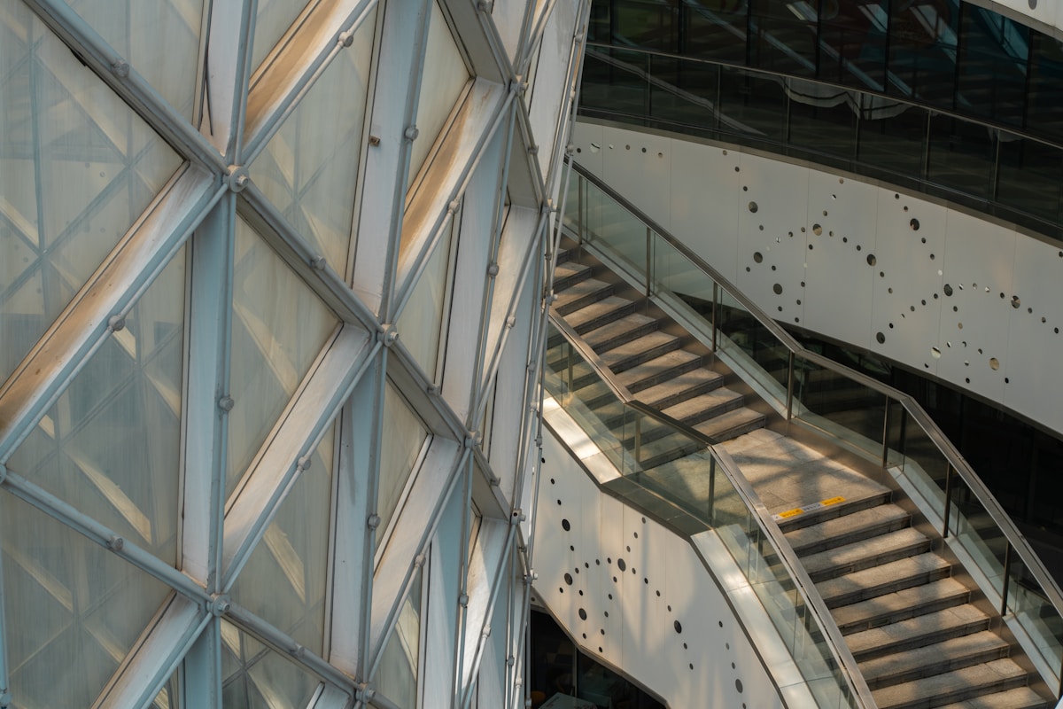 Structure géométrique en verre et métal avec escalier.