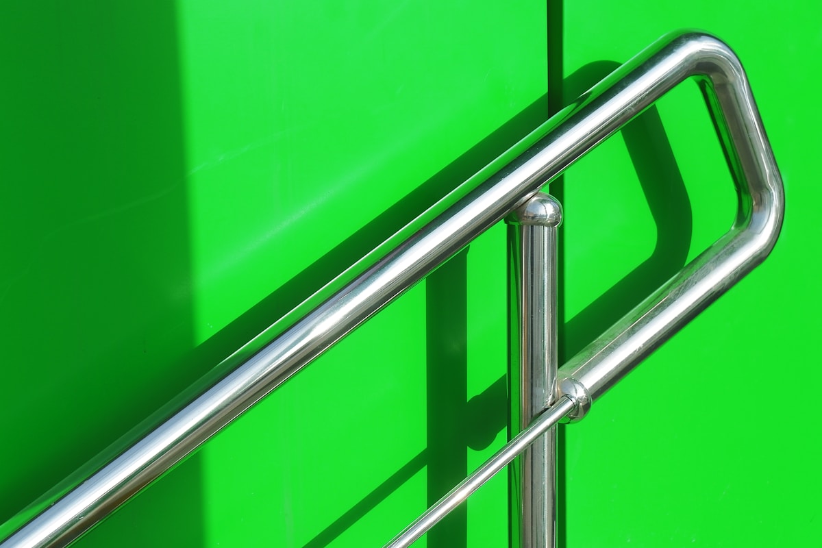 Rambarde métallique chromée sur fond vert vif.